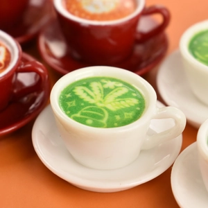 Macro detail of miniature Christmas coffee cups and saucers with latte art for dollhouse decor