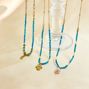 Detail von Perlenketten mit blauem Chalcedon, Hamsa-Hand und goldenen Blattanhängern