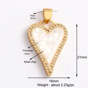 Macro detail of heart charm with white shell mosaic inlay and cubic zirconia stones