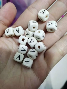 Detailed view of white silicone beads with black letter A for DIY craft keychain projects