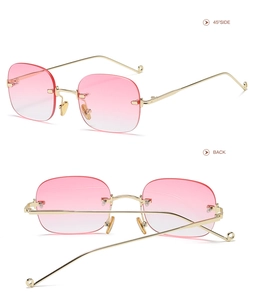 Detail view of pink gradient lenses and golden metal temples on rimless square sunglasses