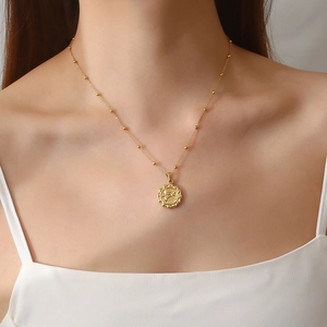 Detailed view of Cupid relief pendant with golden bead chain on a female model