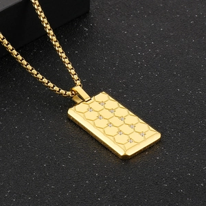 Vue détaillée du pendentif rectangulaire doré gravé en nid d'abeille avec petits diamants