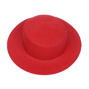 Close-up of vibrant red woven straw hat featuring classic flat top and wide brim design