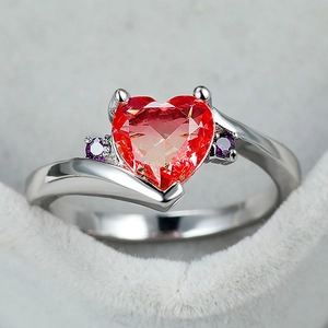 Elegant silver heart-shaped red zircon ring with purple side stones on grey velvet box
