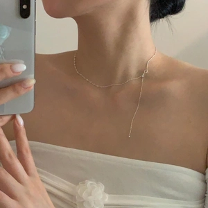 Close-up of S925 sterling silver pig nose Y-necklace worn by model in mirror