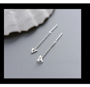 Macro detail of S999 sterling silver letter A ear threads with trendy minimalist design