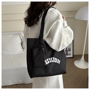 Detail of black large-capacity Oxford tote bag with mini pouch and FASHION lettering