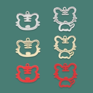Detail of Christmas tiger charms in gold, silver, and red enamel alloy for DIY crafts
