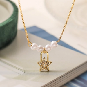 Detailed close-up of a star pendant with crystals and pearls on a gold-tone necklace