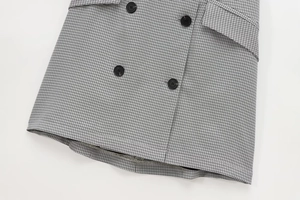 Detail of black and white houndstooth fabric with premium resin buttons on the dress