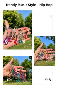 Colorful stainless steel guitar and gecko keychains shown on a grassy background