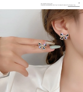 Detail view of s925 gold bow earrings with crystals worn by a model for elegant style