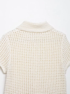 Gros plan d'un haut en crochet blanc montrant la texture en maille et l'encolure