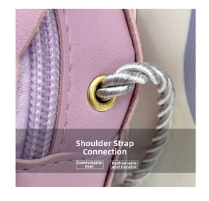 Détail de la bandoulière tressée argentée et de l'œillet métallique du sac en cuir violet