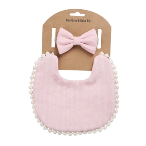 Baby-Set aus rosa Baumwoll-Latz und Schleifen-Stirnband mit weißer Bommelborte und Textur