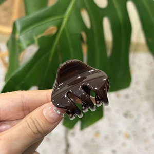 Detailed close-up of a brown tortoiseshell hair claw clip with a glossy finish