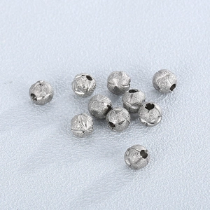 Close-up of frosted and engraved silver stainless steel beads with small center holes