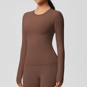 Détail d'un ensemble de yoga marron extensible avec haut à manches longues et legging