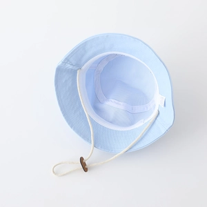 Detail view of the breathable white mesh lining and adjustable chin strap on a sun hat