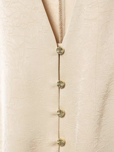 Détails de chemise cintrée en tissu beige froissé avec boutons dorés de luxe
