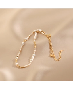 Close-up of baroque freshwater pearl necklace with gold metal tubes on silk fabric