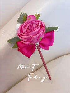 Detail of rose floral pen with pink silk ribbon, satin petals and artificial pearls