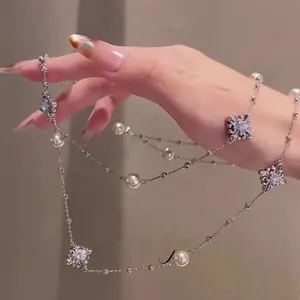 Detailed close-up of diamond floral necklace with elegant pearls on a silver chain
