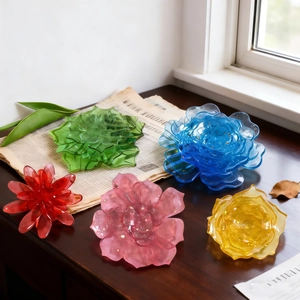Vibrant floral resin molds in five colors with gold foil flakes on a dark wooden surface
