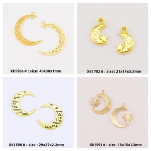 Detail of four golden alloy moon and star pendants with intricate hollow patterns and engraving