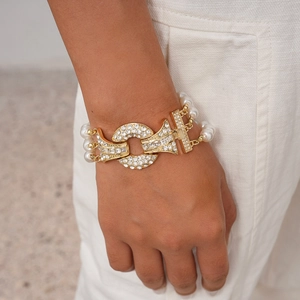 Detailed close-up of multi-layer pearl bracelet with gold metal and diamond buckle