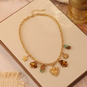Dettaglio collana vintage leopardata con ciondoli cuore e sole dorati su vassoio