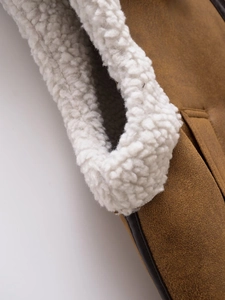 Macro shot of brown suede and white fleece lining detail on the vest collar