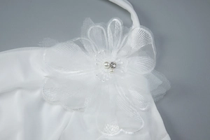 Détail macro d'une fleur en résille multicouche avec perles et strass sur une robe blanche