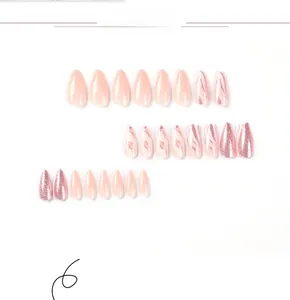 Detailed macro view of almond-shaped press-on nails with pink glitter and marble texture