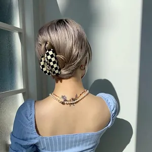 Black and white checkerboard acetate hair claw clip styled on hair in natural light
