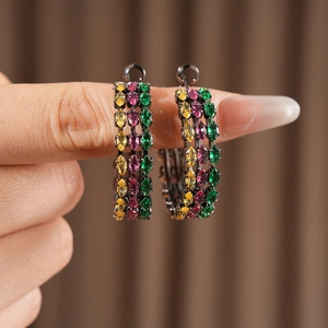 Detailed macro view of vintage hoop earrings featuring three rows of multi-color zircons