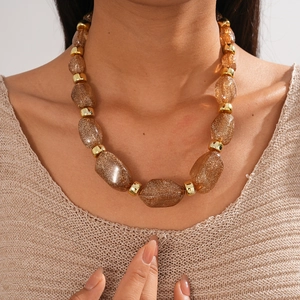 Detailed view of amber resin chunky beads with gold flakes on a statement necklace