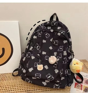 Close-up of black backpack with cartoon bear prints and cute plush charms