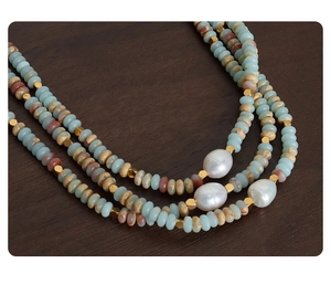 Detail of three-layer beaded necklace featuring baroque pearls and colorful natural stone beads