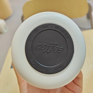 Detailed macro view of the non-slip rubber base and care instructions for the white flask