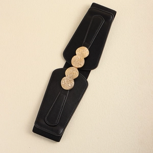 Close-up of black elastic waist belt with three polished gold circular metal buckles