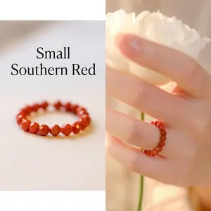 Macro shot of faceted small red agate beaded ring for women with polished gemstone surface