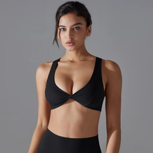 Close-up of black sports bra featuring a twist front detail and high waist leggings