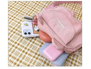 Detail of pink crossbody bag interior showing storage space for phone and essentials
