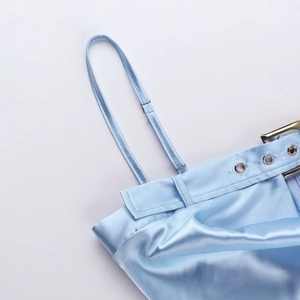 Détail des bretelles réglables et des œillets métalliques sur robe en satin bleu clair