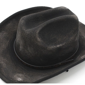 Close-up of distressed black western cowboy hat with brown leather band and buckle