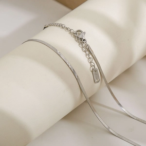 Detail of silver S925 snake chain necklace with lobster clasp on a display stand