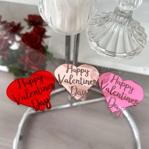 Close-up of heart-shaped acrylic cake toppers with Happy Valentine's Day engraving