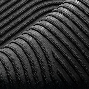 Detail shot of deep 3D grooves and woven texture on a non-slip grey entrance doormat